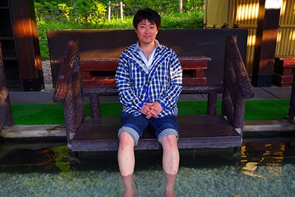 足湯につかっている男性