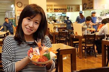 札幌場外市場で海鮮丼を持つ女性